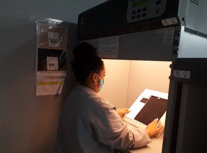 A technician evaluating fabric shade inside a colour light evaluation box.